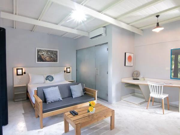 Classic Room at Reef Beach Resort: bed with grey linens, a sofa and a small dining table by the window.