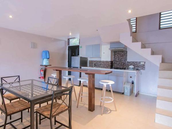 Three Bedroom Suite at Reef Beach Resort: open kitchen and dining area with a staircase up to the bedrooms.