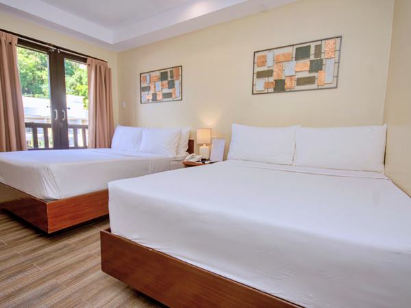 Family Suite at Serene La Playa: beds beside sliding doors opening onto a planted balcony.