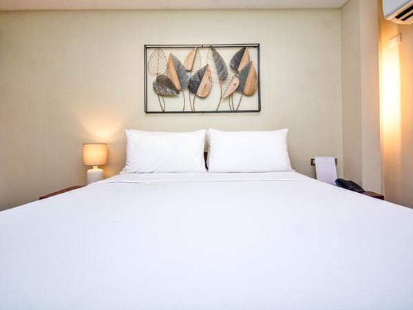 Standard Room at Serene La Playa: queen bed with white linens, framed artwork above and a lamp either side.